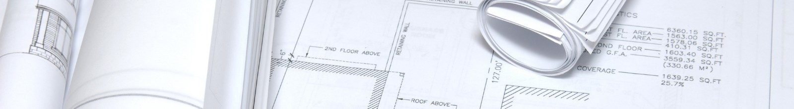 Building plans are sprawled out a table