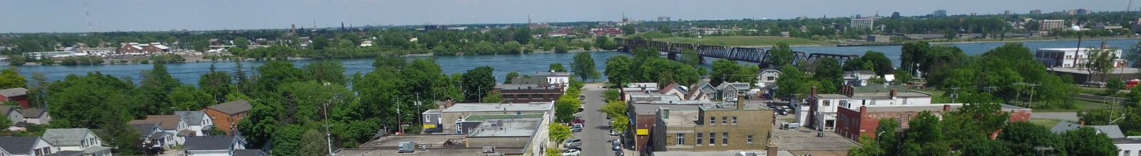 A road lined with shops leading to a river