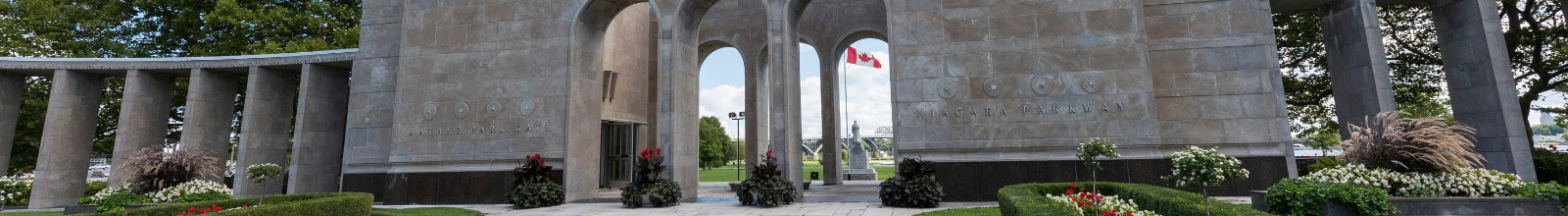 A large structure with arches with a statue in front 