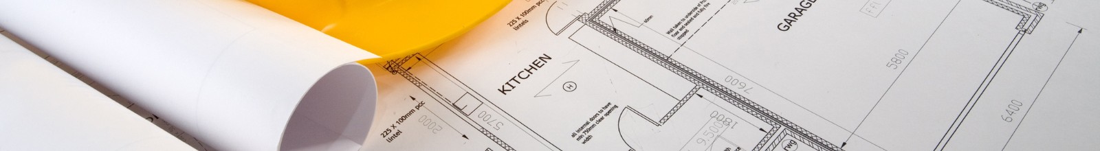 A building plan lays out on a table