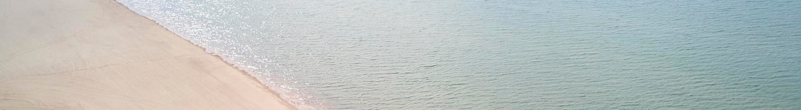 A sandy beach runs along a large lake