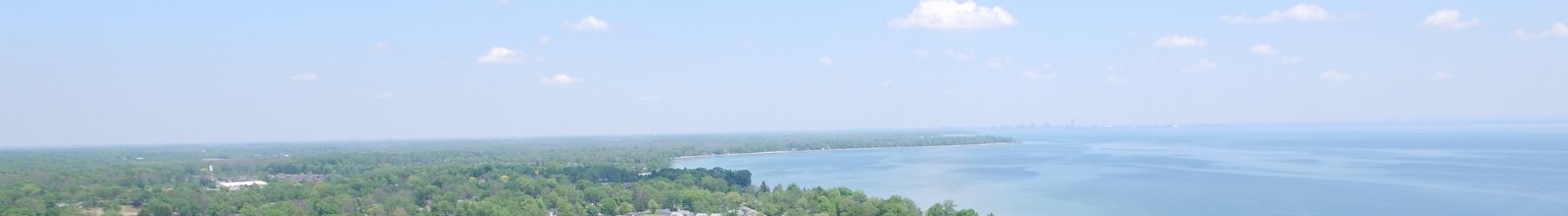 A large lake flows into a river with a green shoreline 