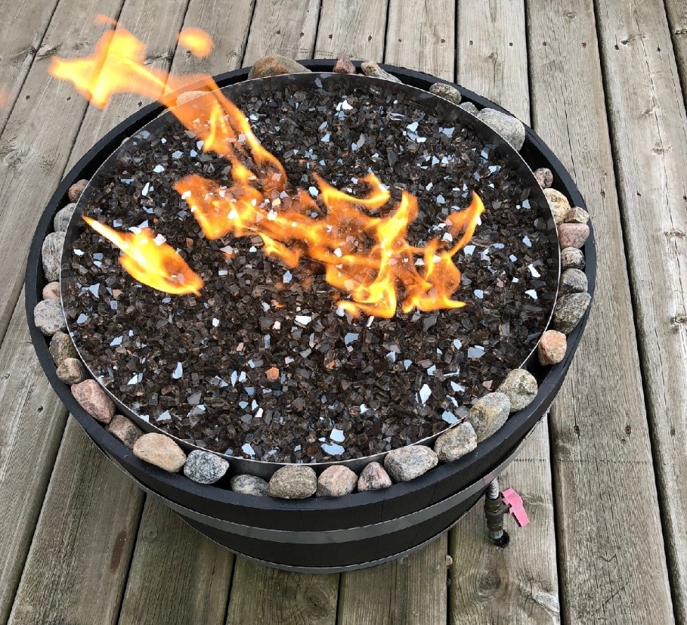 A small fire sits within a small metal pit