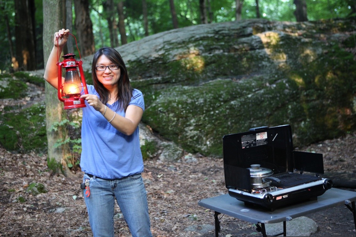 A person holding up a gas lantern