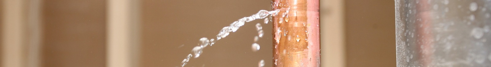 A pipe has a water leak shooting water out