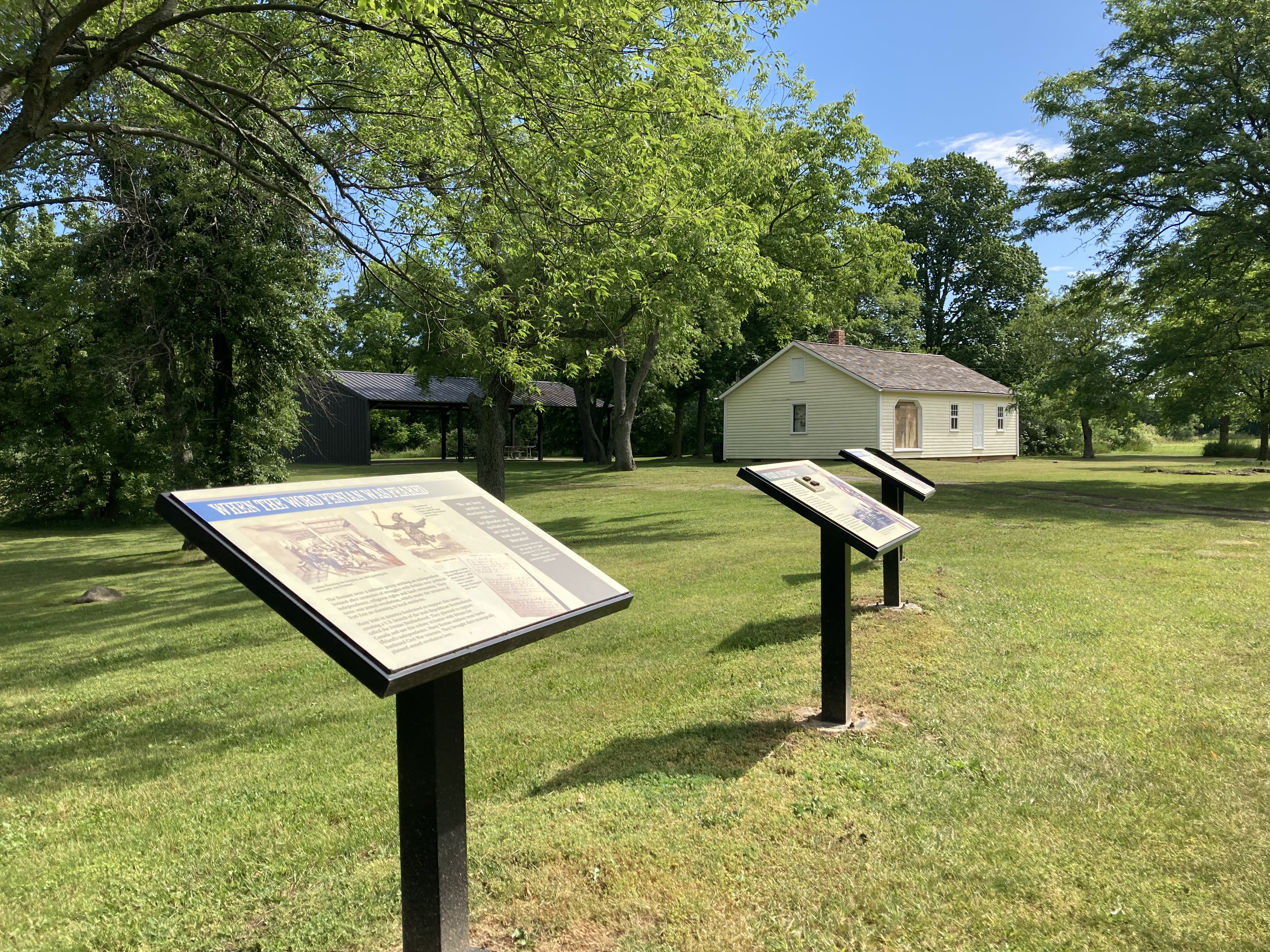 Two historical information stands in a large field