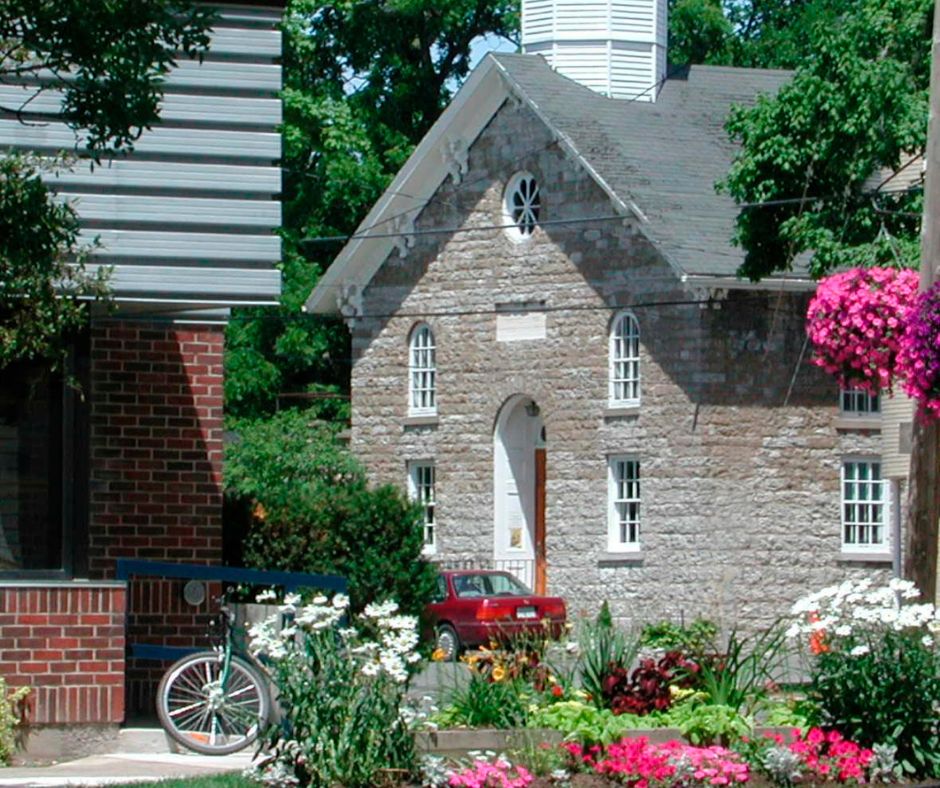 A large old stone building with flowers.