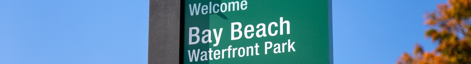 A green sign that says Welcome to Bay Beach