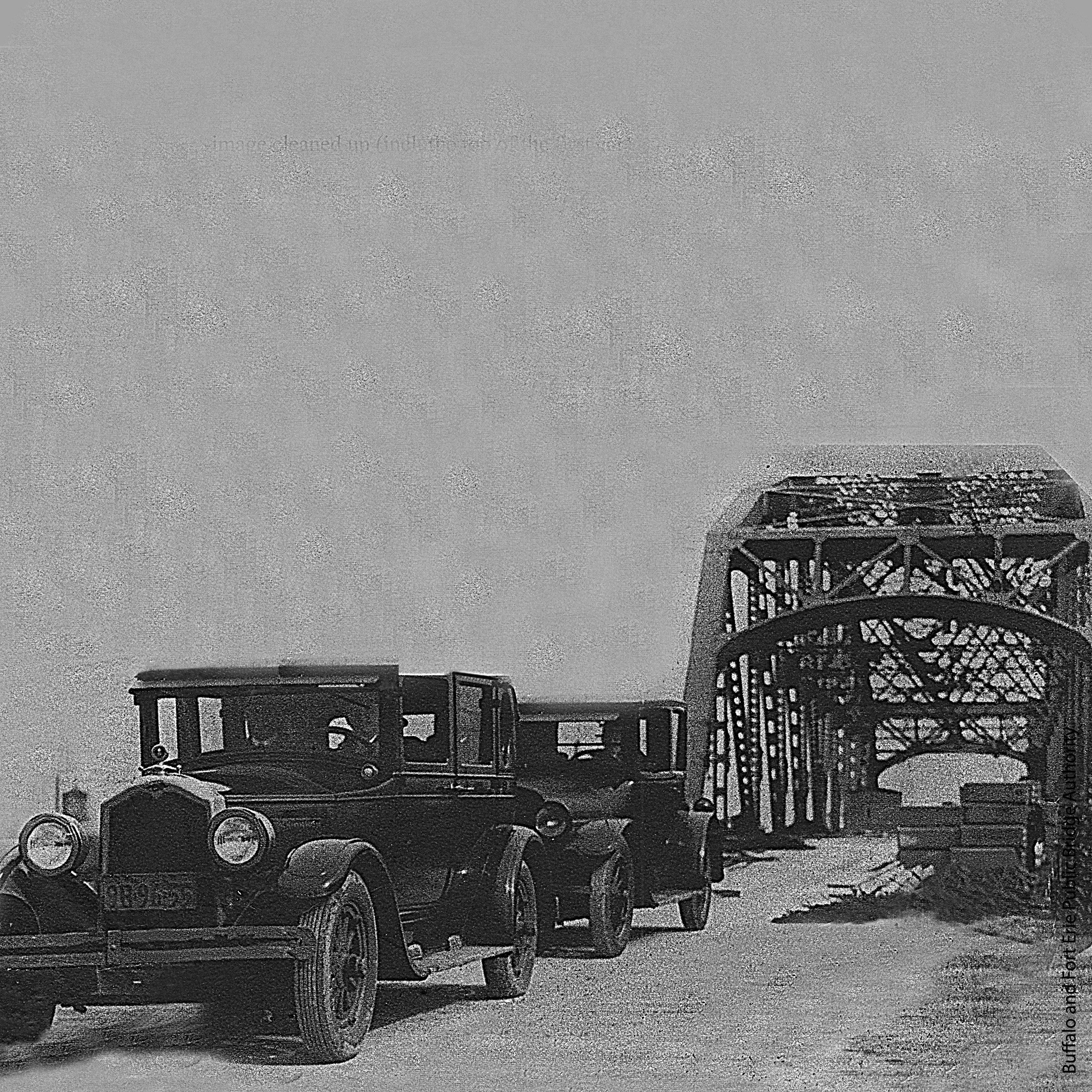Cars go over a bridge with a large arch structure 