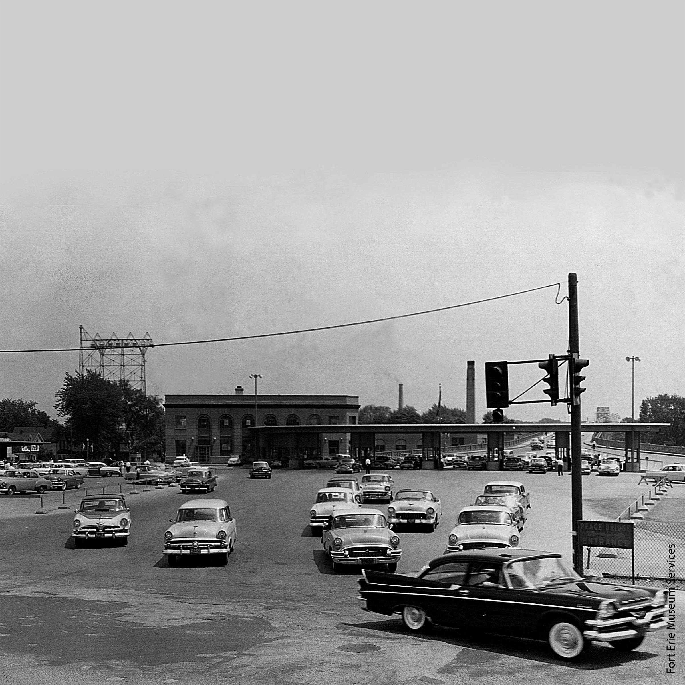 A building with cars packed all around it from the 1960s