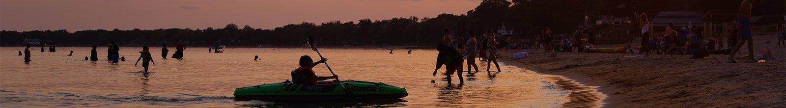 People at the beach - kayak in the water - sun setting