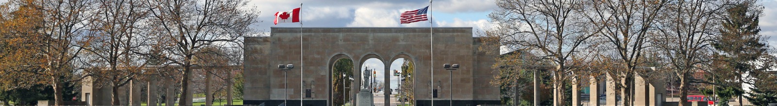 A large structure with arches in front of a field in the fall