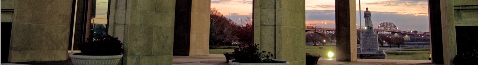 A statue with large stone arches in front of it.