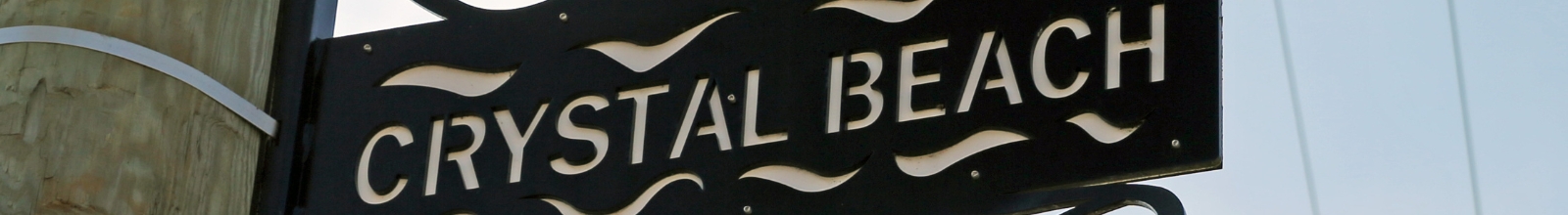 A metal sign with Crystal Beach cut into it