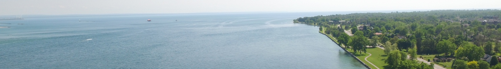 A large river runs into a large lake with a shoreline along the right
